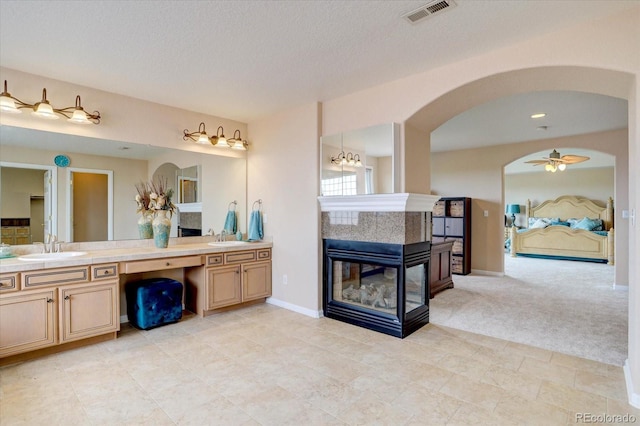 15857 E Aberdeen Ave, Centennial, CO 80016 - ensuite bathroom with double vanity, a tile fireplace, ceiling fan, a textured ceiling, and tile patterned floors