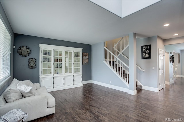 living room featuring recessed lighting, baseboards, dark wood-style flooring, and stairs