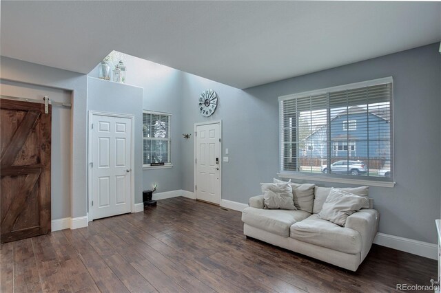 interior space with baseboards, a barn door, and dark wood-style floors