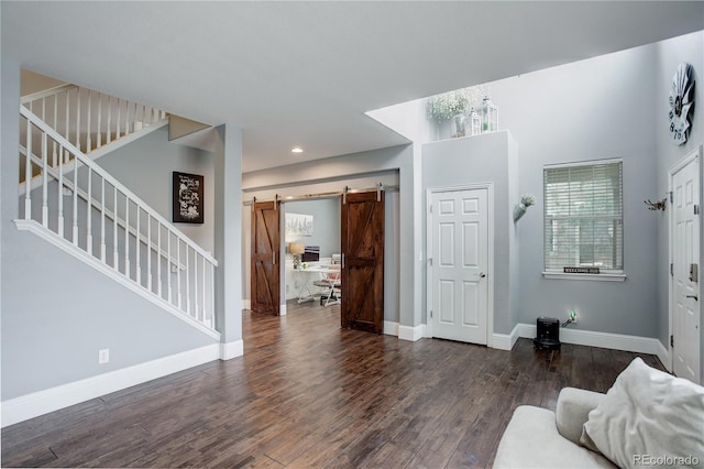 living area featuring stairs, baseboards, a barn door, and wood finished floors