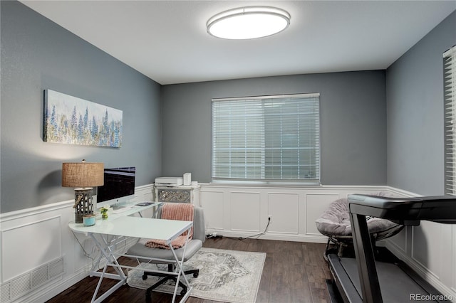 office area with visible vents, wainscoting, dark wood-style flooring, and a decorative wall