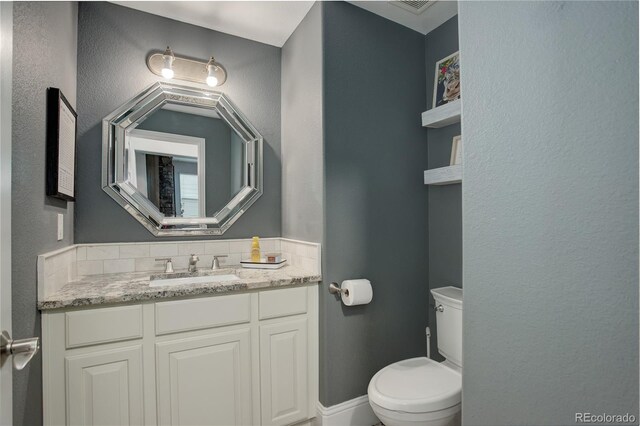 half bathroom with vanity and toilet