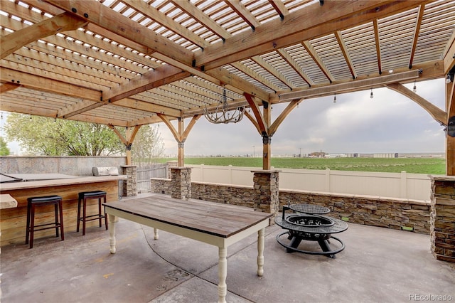 view of patio / terrace featuring a fire pit, a fenced backyard, and outdoor dry bar