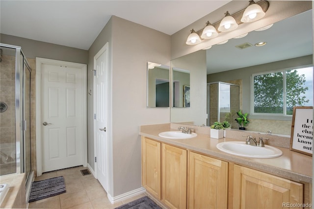 full bathroom featuring tile patterned floors, visible vents, a shower stall, and a sink