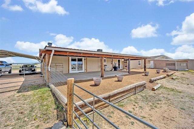 5856 John Ross Ct, Peyton, CO 80831 - view of front facade with metal roof, a carport, an outbuilding, and a patio area