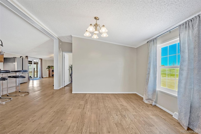 5856 John Ross Ct, Peyton, CO 80831 - unfurnished dining area with a chandelier, plenty of natural light, wood finished floors, a textured ceiling, and baseboards