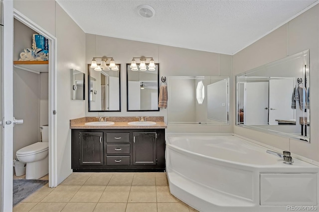 5856 John Ross Ct, Peyton, CO 80831 - bathroom with double vanity, tile patterned floors, a bath, toilet, and a textured ceiling