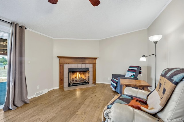 5856 John Ross Ct, Peyton, CO 80831 - sitting room with a ceiling fan, light wood finished floors, ornamental molding, a fireplace, and baseboards