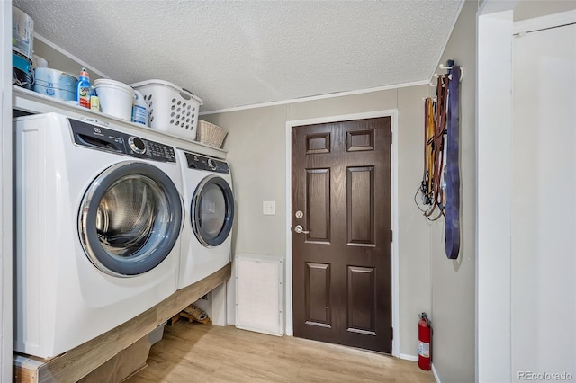 5856 John Ross Ct, Peyton, CO 80831 - laundry room with washer and dryer, light wood finished floors, a textured ceiling, and crown molding