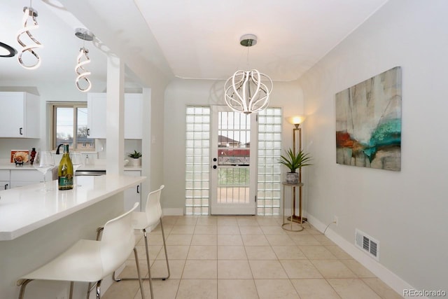 tiled dining space featuring a notable chandelier