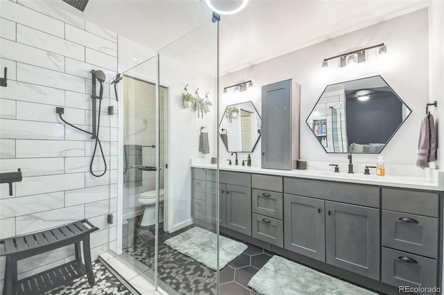 full bathroom featuring a stall shower, tile patterned floors, double vanity, and toilet