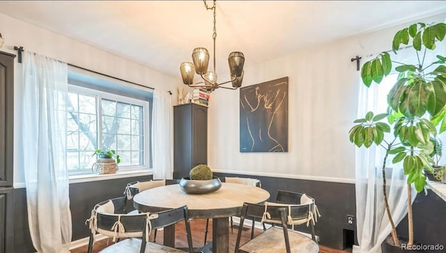 dining space with a chandelier and wood finished floors