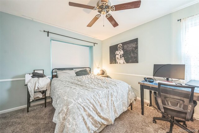 carpeted bedroom with baseboards, ceiling fan, and a desk