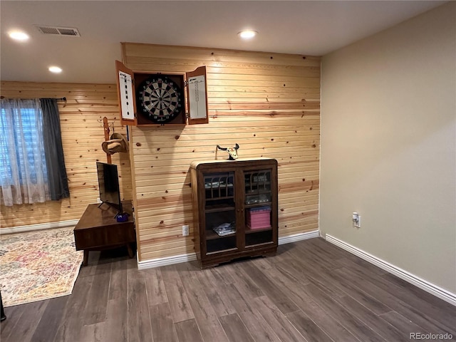 bar with dark wood-type flooring, wooden walls, baseboards, and visible vents