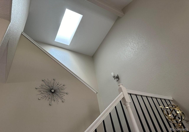 staircase with vaulted ceiling with skylight