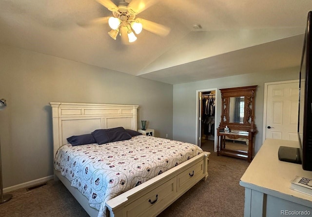 bedroom with a spacious closet, visible vents, lofted ceiling, a closet, and dark colored carpet