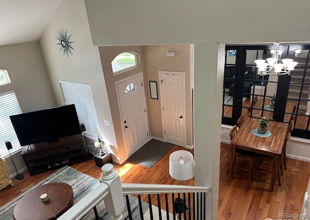 entryway with wood-type flooring and a notable chandelier