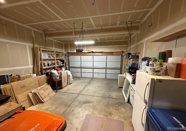 garage with a garage door opener and freestanding refrigerator