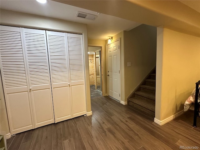 corridor featuring dark wood finished floors, stairway, baseboards, and visible vents