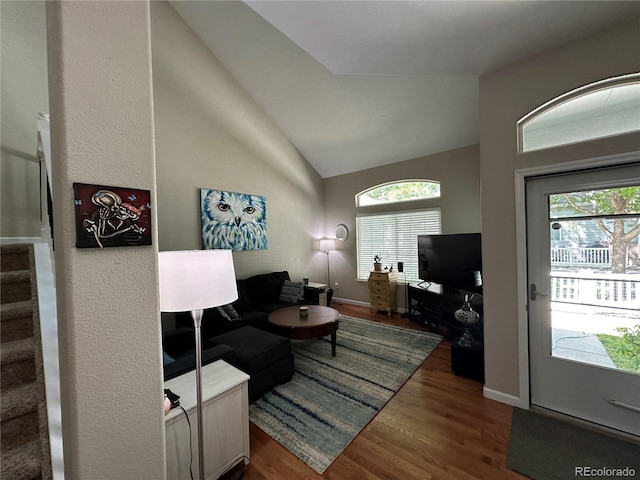 living room featuring vaulted ceiling, plenty of natural light, and dark wood-type flooring