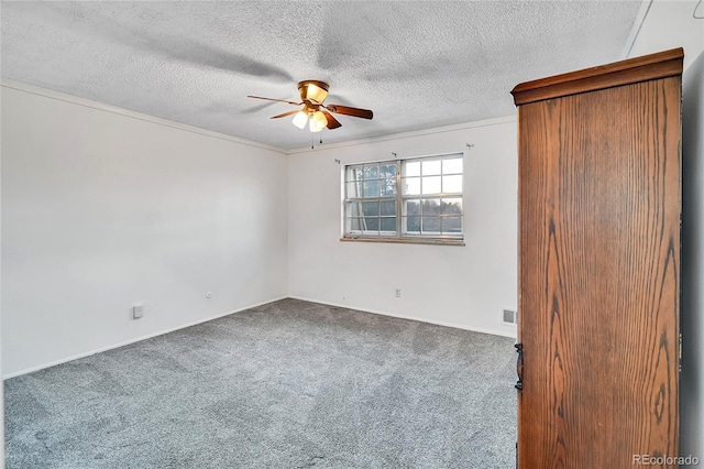 unfurnished room with carpet flooring, ceiling fan, crown molding, and a textured ceiling