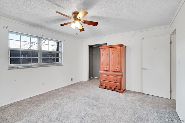 unfurnished bedroom with light carpet, a textured ceiling, and ceiling fan