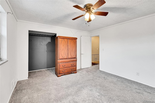 unfurnished bedroom with ceiling fan, a textured ceiling, light carpet, and a closet