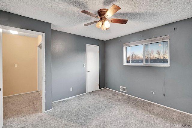 spare room with light carpet, a textured ceiling, and ceiling fan