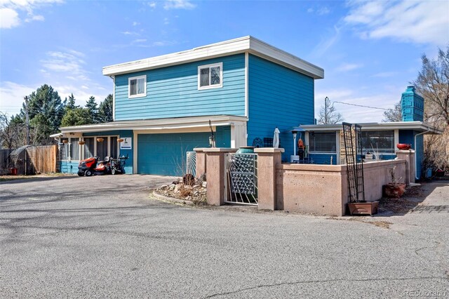 7400 W Quincy Ave, Littleton, CO 80123 - view of front of property with a fenced front yard, asphalt driveway, an attached garage, and a chimney