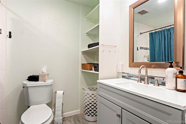 7400 W Quincy Ave, Littleton, CO 80123 - full bath with vanity, wood finished floors, and a shower with curtain
