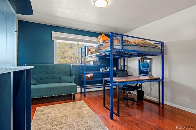 7400 W Quincy Ave, Littleton, CO 80123 - bedroom featuring an office area, wood finished floors, and a baseboard heating unit