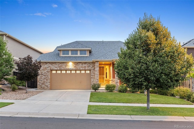 4875 S Catawba St, Aurora, CO 80016 - view of front of home with brick siding, a shingled roof, a front yard, and driveway