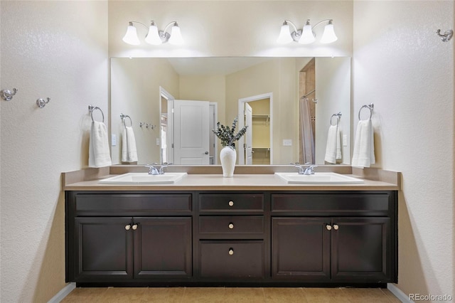 4875 S Catawba St, Aurora, CO 80016 - bathroom featuring double vanity, tile patterned flooring, and a textured wall