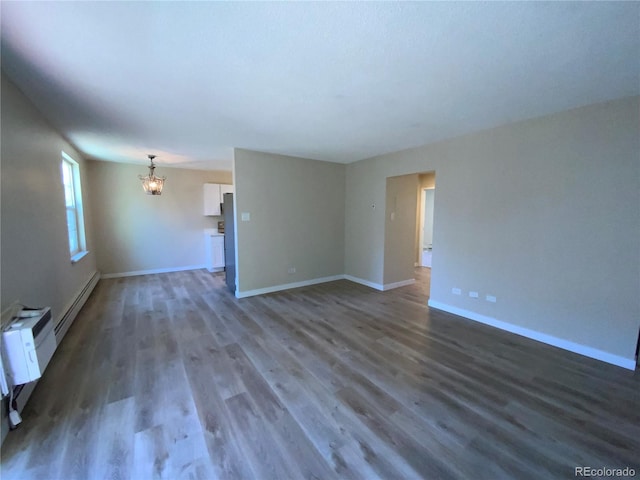 unfurnished living room featuring a baseboard heating unit, a notable chandelier, and dark hardwood / wood-style floors