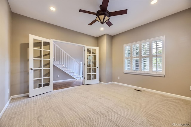 carpeted empty room with ceiling fan and french doors