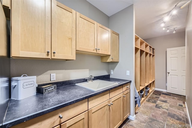 kitchen with rail lighting, sink, and light brown cabinets