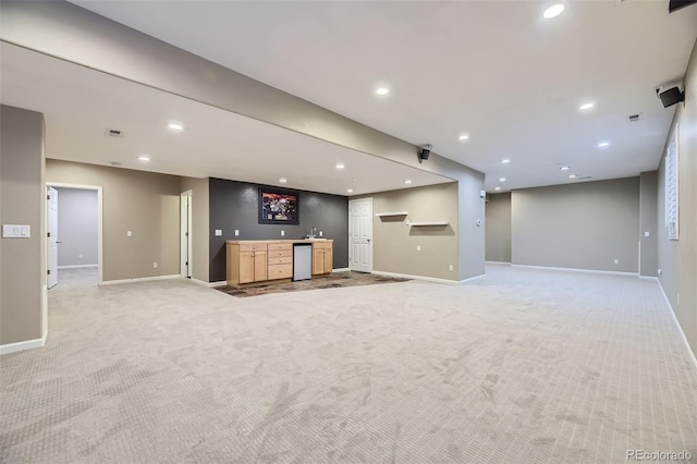 unfurnished living room featuring light carpet and bar