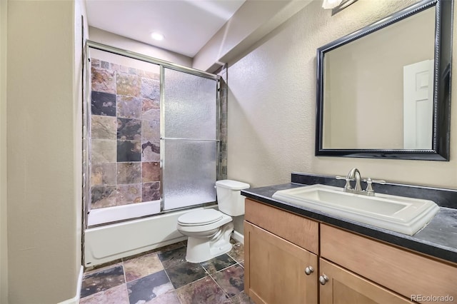 full bathroom with vanity, combined bath / shower with glass door, and toilet