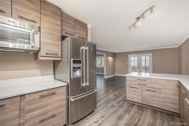 kitchen with french doors, crown molding, stainless steel appliances, light countertops, and dark wood-type flooring