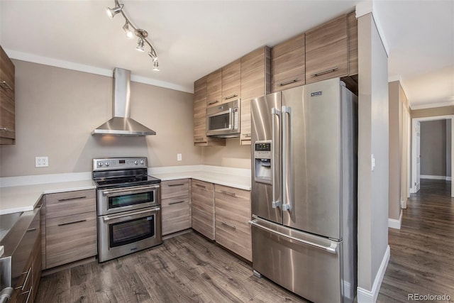 kitchen featuring wall chimney exhaust hood, appliances with stainless steel finishes, ornamental molding, dark wood-style flooring, and light countertops