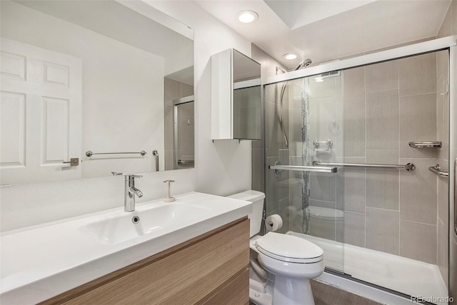 full bathroom featuring toilet, a stall shower, recessed lighting, and vanity