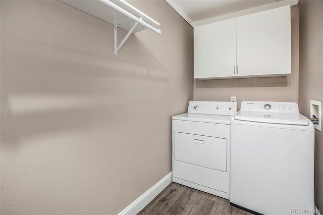 washroom with cabinet space, baseboards, separate washer and dryer, and wood finished floors