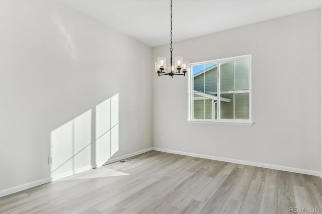 unfurnished dining area featuring a notable chandelier and light hardwood / wood-style floors