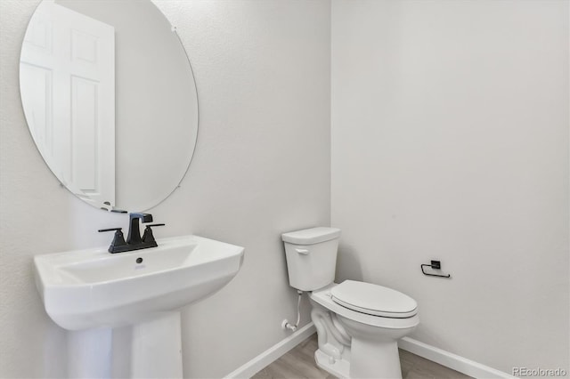 bathroom with sink, wood-type flooring, and toilet