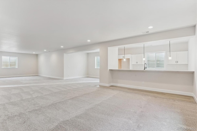 unfurnished room featuring light carpet and plenty of natural light