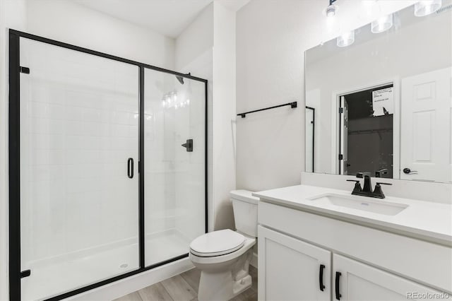 bathroom featuring vanity, hardwood / wood-style flooring, toilet, and an enclosed shower