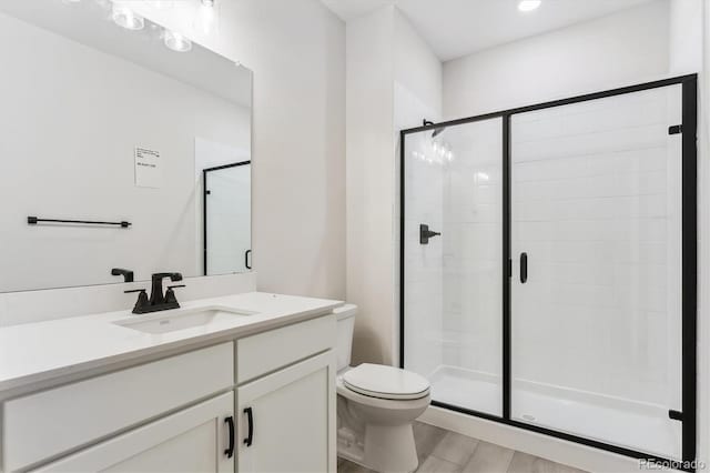 bathroom featuring toilet, vanity, a shower with door, and hardwood / wood-style flooring