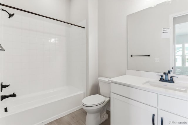 full bathroom featuring vanity, hardwood / wood-style floors, tiled shower / bath combo, and toilet