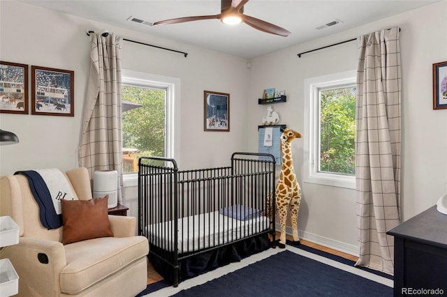 1265 S Elizabeth St, Denver, CO 80210 - bedroom featuring multiple windows, a crib, ceiling fan, and wood finished floors