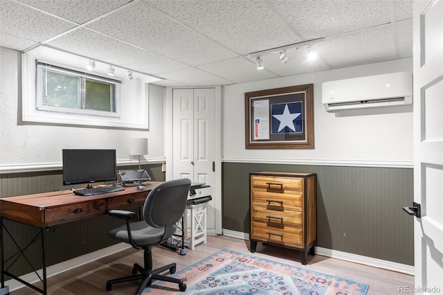 1265 S Elizabeth St, Denver, CO 80210 - home office with rail lighting, a wall unit AC, light wood-type flooring, a wainscoted wall, and a drop ceiling